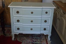 A cream and gilt painted three drawer commode.