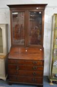 A George III mahogany bureau with later bookcase top.