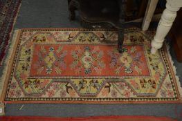 A small pink ground carpet with stylized decoration, 137cms x 77cms.