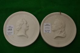 A pair of circular bisque porcelain portrait plaques.