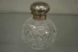 A silver topped cut glass scent bottle.