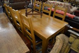 A modern oak rectangular dining table with six similar chairs (seats worn).