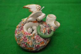 An unusual porcelain inkwell modelled as a nest with a bird and eggs being attacked by a snake.