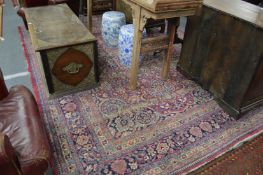 A large Kashan carpet, red ground with stylized floral decoration, badly worn in places, 350cms x