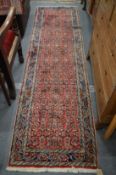 A modern Persian style runner, pink ground with floral decoration, 275cms x 75cms.