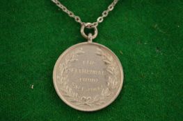 A silver coin pendant and chain.