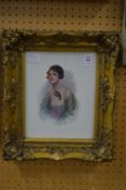 A bust length portrait of a young lady holding a mask colour print in a decorative gilt frame.