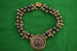 A decorative choker with lion mask decoration.