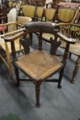 A carved oak corner armchair.