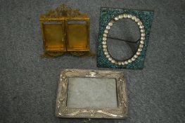 A silver photograph frame and other frames.