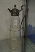 A cut and etched glass claret jug with plated mounts.