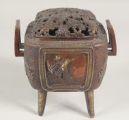 A JAPANESE BRONZE TWIN HANDLE KORO, with foliate openwork lid and raised on four legs, the koro with