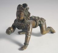 A FINE 18TH CENTURY TIBETAN OR NEPALESE BRONZE FIGURE of Krishna in a crawling position, 15cm long.
