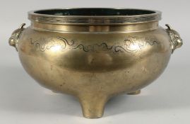 A LARGE CHINESE BRASS TWIN HANDLE TRIPOD CENSER, the handles formed as beast heads, 31cm handle to