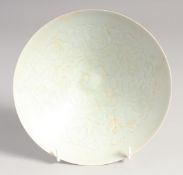 A CHINESE CELADON GLAZE BOWL, with carved decoration to the interior, 18cm diameter.