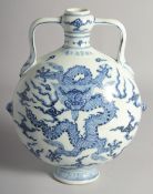 A CHINESE BLUE AND WHITE PORCELAIN TWIN HANDLED MOON FLASK painted with central dragon surrounded by