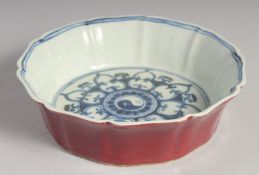 A CHINESE IRON-RED PETAL FORMED BOWL with blue and white interior depicting yin-yang motif, the base