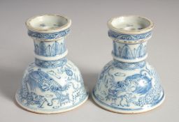 A PAIR OF CHINESE BLUE AND WHITE PORCELAIN CANDLESTICKS, possibly 1900, painted with dragons and