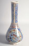 A PERSIAN QAJAR GLAZED POTTERY VASE with long slender neck, the body painted with round panels