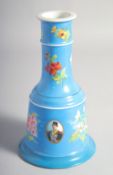 A PERSIAN QAJAR PORCELAIN HUQQA BASE, decorated with oval portraits and sprays of flora, 23cm high.