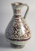 AN ISLAMIC SYRIA RAQQA POTTERY EWER, the body painted with scale motif decoration, 19.5cm high.
