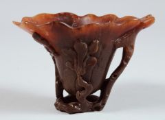 AN 18TH - 19TH CENTURY RHINO LIBATION CUP as a lotus flower with leaves. 3.25ins high x 4.5ins