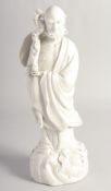 A BLANC-DE-CHINE PORCELAIN FIGURE of a sage holding a staff, the reverse with impressed mark, 34cm