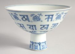 A CHINESE BLUE AND WHITE PORCELAIN STEM CUP painted with lotus and characters, the interior centre