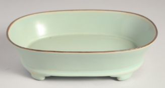 A CHINESE RU WARE CELADON PLANT POT, raised on four feet, 23.5cm wide.
