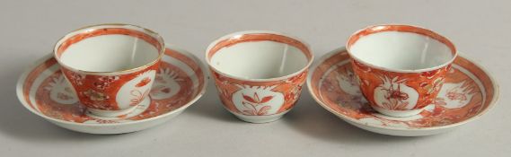 THREE CORAL RED AND WHITE PORCELAIN TEA BOWLS, together with two saucers, cups 6cm diameter, saucers
