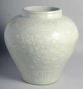A LARGE CHINESE CELADON GLAZED VASE carved with peacocks and flora. 32cm high