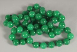 A STRING OF GREEN JADE BEADS. 28