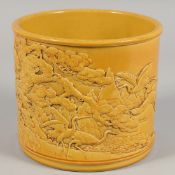 A LARGE CHINESE YELLOW GLAZED PORCELAIN BRUSH POT with relief decoration depicting cranes in a