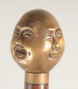 A WALKING STICK with brass four face handle.