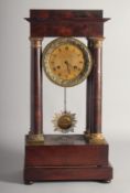 A 19TH CENTURY EMPIRE MAHOGANY PILLAR CLOCK with gilt drum movement, with sunburst pendulums.