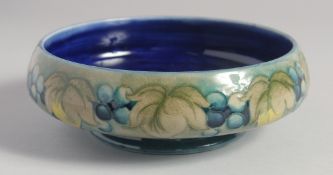 WILLIAM MOORCROFT. GRAPE AND LEAF DESIGN CIRCULAR BOWL with green and blue ground. Impressed: