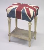 A SMALL STOOL WITH CARVED AND PAINTED LEGS upholstered with a Union Jack fabric.