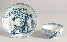 A LIVERPOOL TEABOWL AND SAUCER painted in blue with a version of the Plantation pattern, after