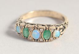 A 9CT GOLD OPAL, DIAMOND AND EMERALD RING.