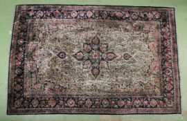 A PART SILK PERSIAN RUG with star centre and floral design. 3ft 6ins x 5ft 7ins.