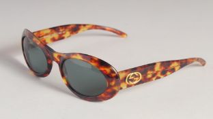 A PAIR OF GUCCI SUNGLASSES in a Gucci case.