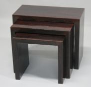 A MODERN NEST OF ROSEWOOD STYLE TABLES. Largest 2ft long x 1ft wide x 1ft 7ins high.