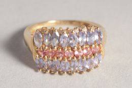A 14CT GOLD THREE ROW TANZANITE AND RUBY RING.