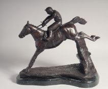 A HORSE RACING BRONZE, Horse and Jockey over sticks on a marble base.