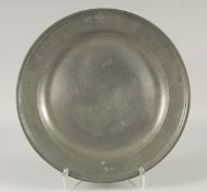 AN EARLY PEWTER CIRCULAR DISH. 14.5ins diameter.