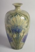 WILLIAM MOORCROFT FLORIAN DESIGN VASE with blue cornflowers on a green ground. Signed: W.