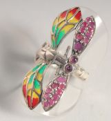 A SILVER RUBY PLIQUE ENAMEL DRAGONFLY RING.