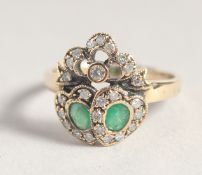 A 9CT GOLD EMERALD AND DIAMOND DOUBLE HEART SWEETHEART RING.
