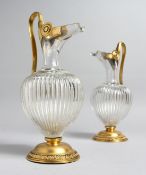 A VERY GOOD PAIR OF POSSIBLY FRENCH, CRYSTAL AND GILT METAL EWERS. 10ins high.
