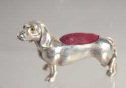 A SILVER DACHSHUND PIN CUSHION.